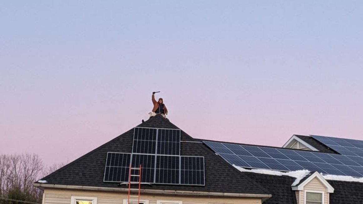 Man working on solar installation on roof